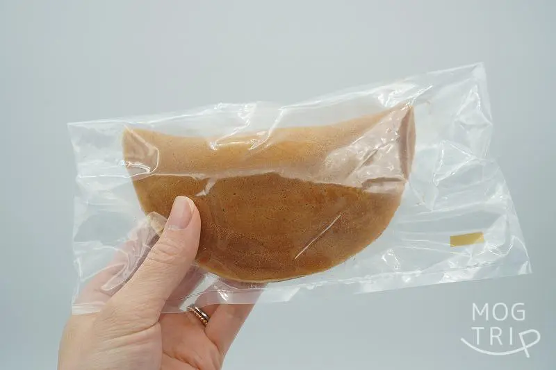 千秋庵総本家の「中花饅頭」を手に持っている様子