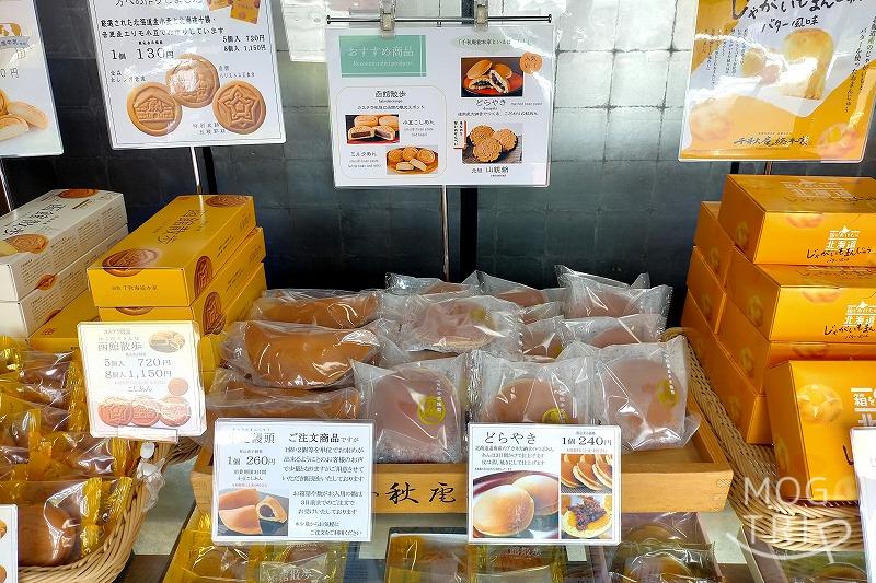 千秋庵総本家 宝来町本店のどら焼き、中花まんじゅうが木の箱の中に並べられている